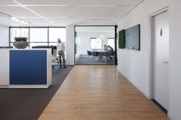 Moderne kantoorruimte in Rivium Quadrant met glazen vergaderruimte, werkplekken en licht houten vloer.